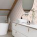 Интерьер ванной комнаты с обоями в стиле Ар Деко украшенными веерным золотым узором на нежно розовом фоне